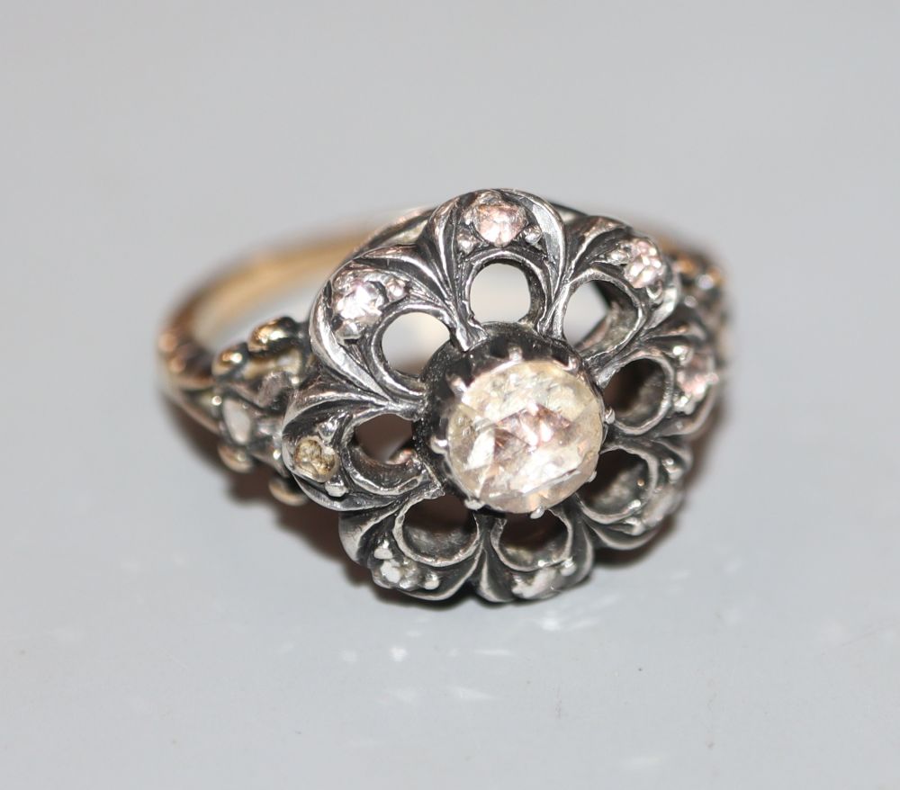 A 19th century yellow metal and diamond cluster set pierced openwork ring, size L, gross 5.6 grams.